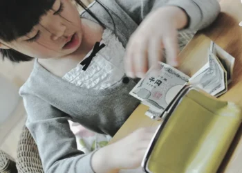 Child in Japan counting money received as New Year’s gift at home in Sapporo, Hokkaido.