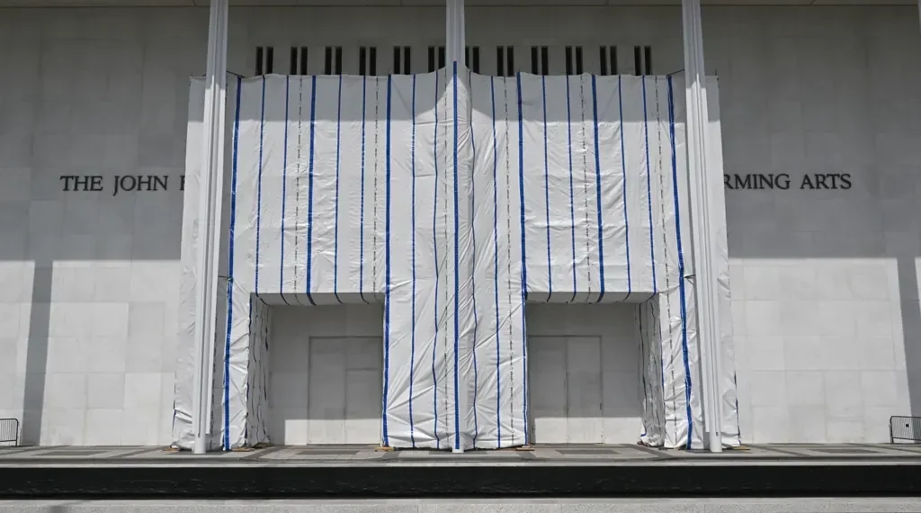 John F. Kennedy Center for the Performing Arts in Washington, D.C., with its exterior name partially covered by white scaffolding sheeting.