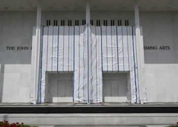 John F. Kennedy Center for the Performing Arts in Washington, D.C., with its exterior name partially covered by white scaffolding sheeting.