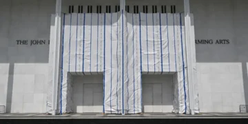 John F. Kennedy Center for the Performing Arts in Washington, D.C., with its exterior name partially covered by white scaffolding sheeting.