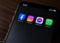 A smartphone displays Facebook, Instagram, Messenger and WhatsApp apps on its screen in a close-up original photograph.