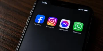 A smartphone displays Facebook, Instagram, Messenger and WhatsApp apps on its screen in a close-up original photograph.