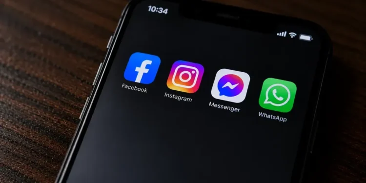 A smartphone displays Facebook, Instagram, Messenger and WhatsApp apps on its screen in a close-up original photograph.