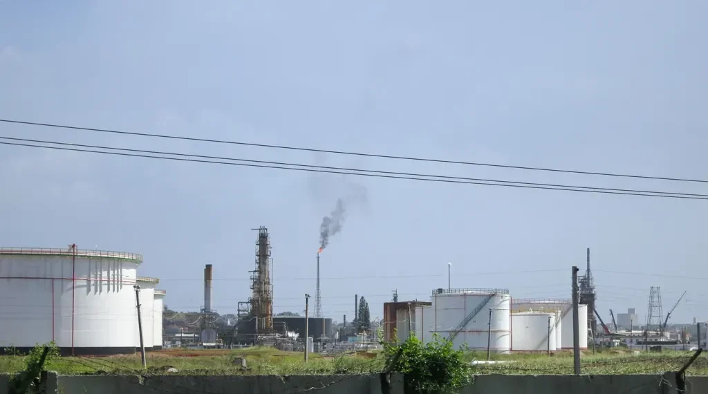 Oil refinery near Regla in Havana, Cuba, viewed from the surrounding area with industrial processing structures visible.