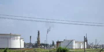 Oil refinery near Regla in Havana, Cuba, viewed from the surrounding area with industrial processing structures visible.