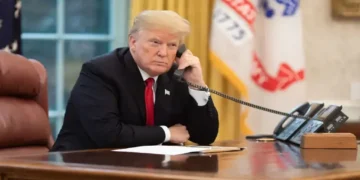 U.S. president speaks on the phone in the Oval Office while receiving an update about devastating California wildfires in November 2018.