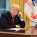 U.S. president speaks on the phone in the Oval Office while receiving an update about devastating California wildfires in November 2018.