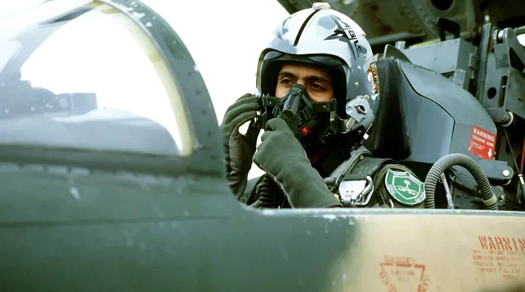 Royal Saudi Arabian Air Force pilot adjusts an oxygen mask inside an F-5 Tiger II cockpit before a training mission in 1982.
