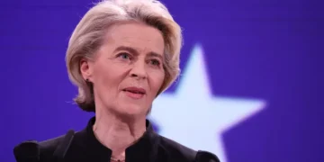 Ursula von der Leyen stands at a podium during a European ceremony honoring former Commission President Jacques Delors in Brussels.