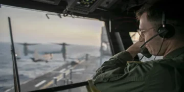 U.S. Navy officer oversees flight operations from USS Tripoli’s control tower as the amphibious assault ship sails in the Arabian Sea.