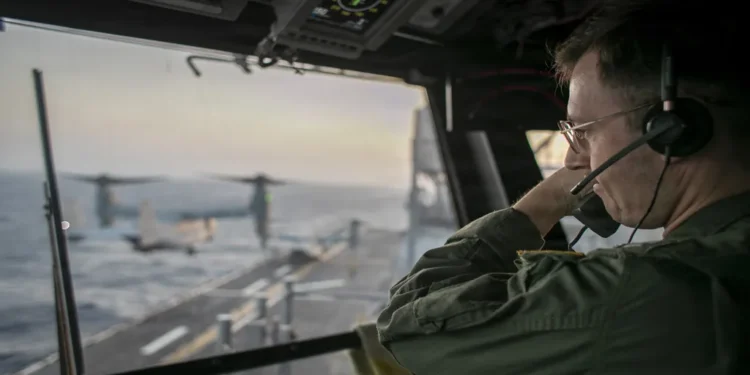 U.S. Navy officer oversees flight operations from USS Tripoli’s control tower as the amphibious assault ship sails in the Arabian Sea.