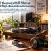 Vinyl record playing on a turntable beside headphones, speakers, records, plants and music books in a bright home listening space