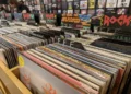 Vinyl records displayed in a music store, showing rows of physical albums available for purchase.
