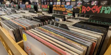 Vinyl records displayed in a music store, showing rows of physical albums available for purchase.