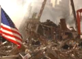 Rescue workers search through World Trade Center rubble beneath an American flag in New York City after the September 11 attacks.