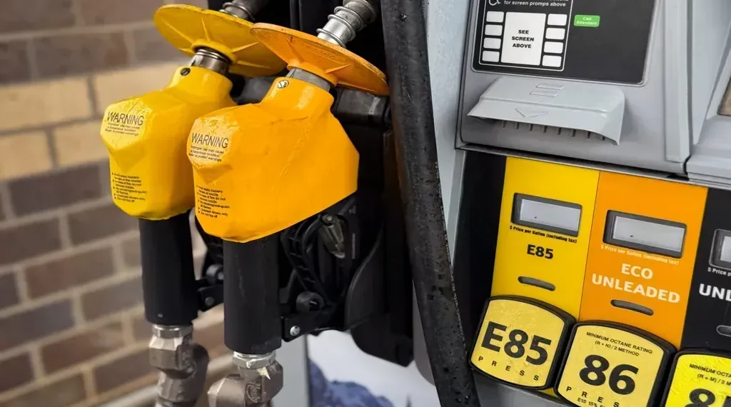 Yellow gasoline pump displaying E85, E15, and Eco Unleaded fuel options at a service station.