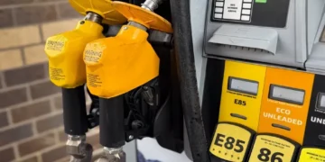 Yellow gasoline pump displaying E85, E15, and Eco Unleaded fuel options at a service station.