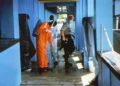 A photographer has the soles of their shoes sprayed with disinfectant after leaving an infected area during the 1995 Ebola outbreak in Kikwit, Zaire.