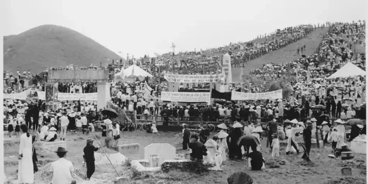 City officials in Hue, Vietnam, arrange coffins before funeral services for victims of the 1968 Tet Offensive, in a U.S. military archival photograph.
