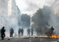 Police fire tear-gas grenades using a Cougar launcher near Porte Saint-Martin during a demonstration in Paris.