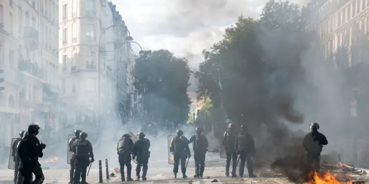 Police fire tear-gas grenades using a Cougar launcher near Porte Saint-Martin during a demonstration in Paris.