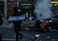 A demonstrator holds a République–Voltaire sign during protests in Paris on October 17, 2026.