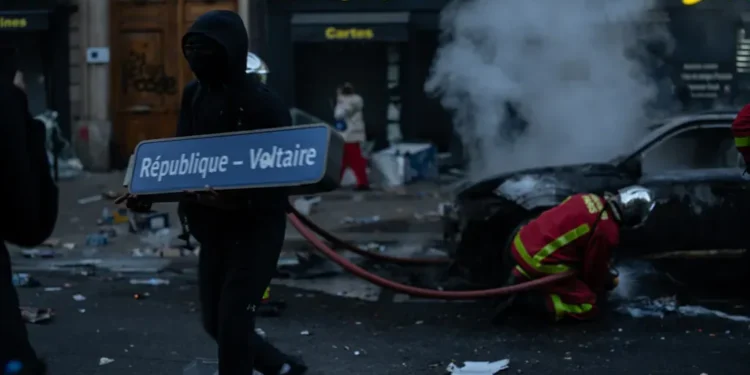 A demonstrator holds a République–Voltaire sign during protests in Paris on October 17, 2026.