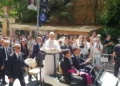 Pope Leo XIV raises his hand to greet pilgrims, volunteers and Mossos d'Esquadra officers at Montserrat Abbey in Spain.