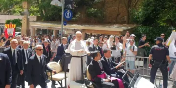 Pope Leo XIV raises his hand to greet pilgrims, volunteers and Mossos d'Esquadra officers at Montserrat Abbey in Spain.