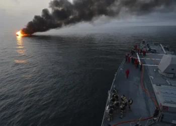 Sailors aboard USS William P. Lawrence prepare to assist a burning vessel during a transit of the Strait of Hormuz on March 11, 2013.