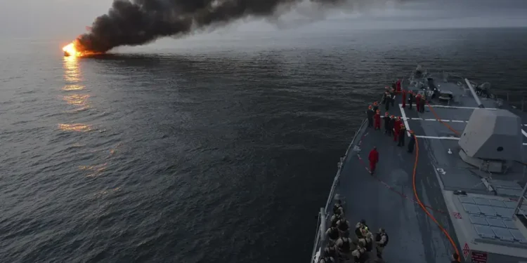 Sailors aboard USS William P. Lawrence prepare to assist a burning vessel during a transit of the Strait of Hormuz on March 11, 2013.